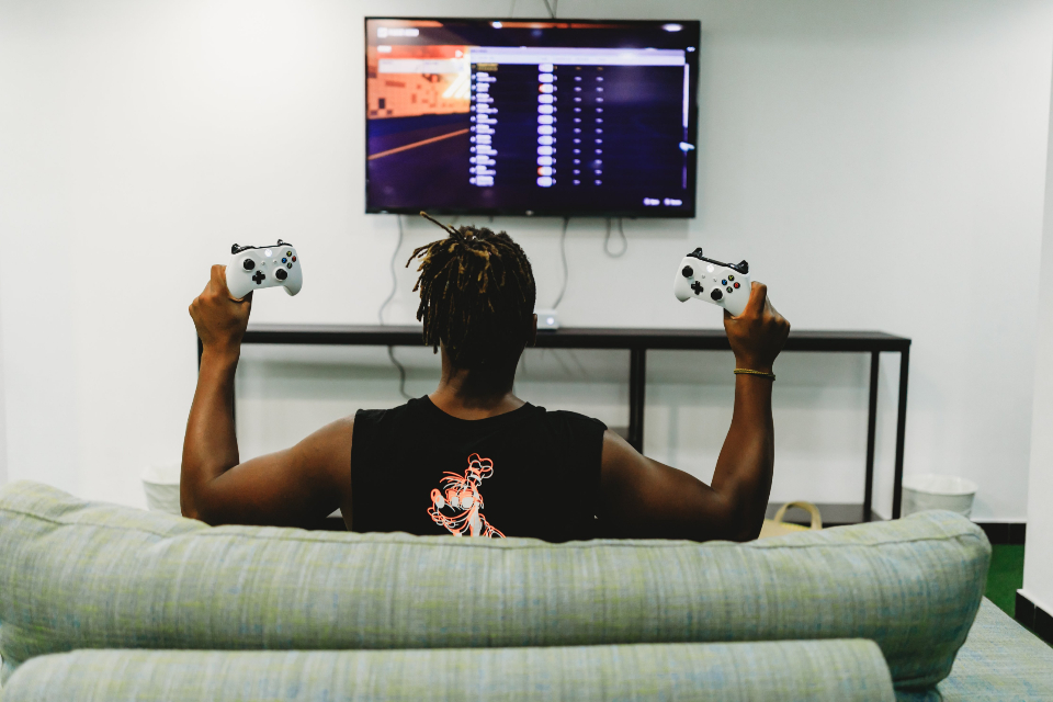 Player relaxing with a video game controller in front of a screen
